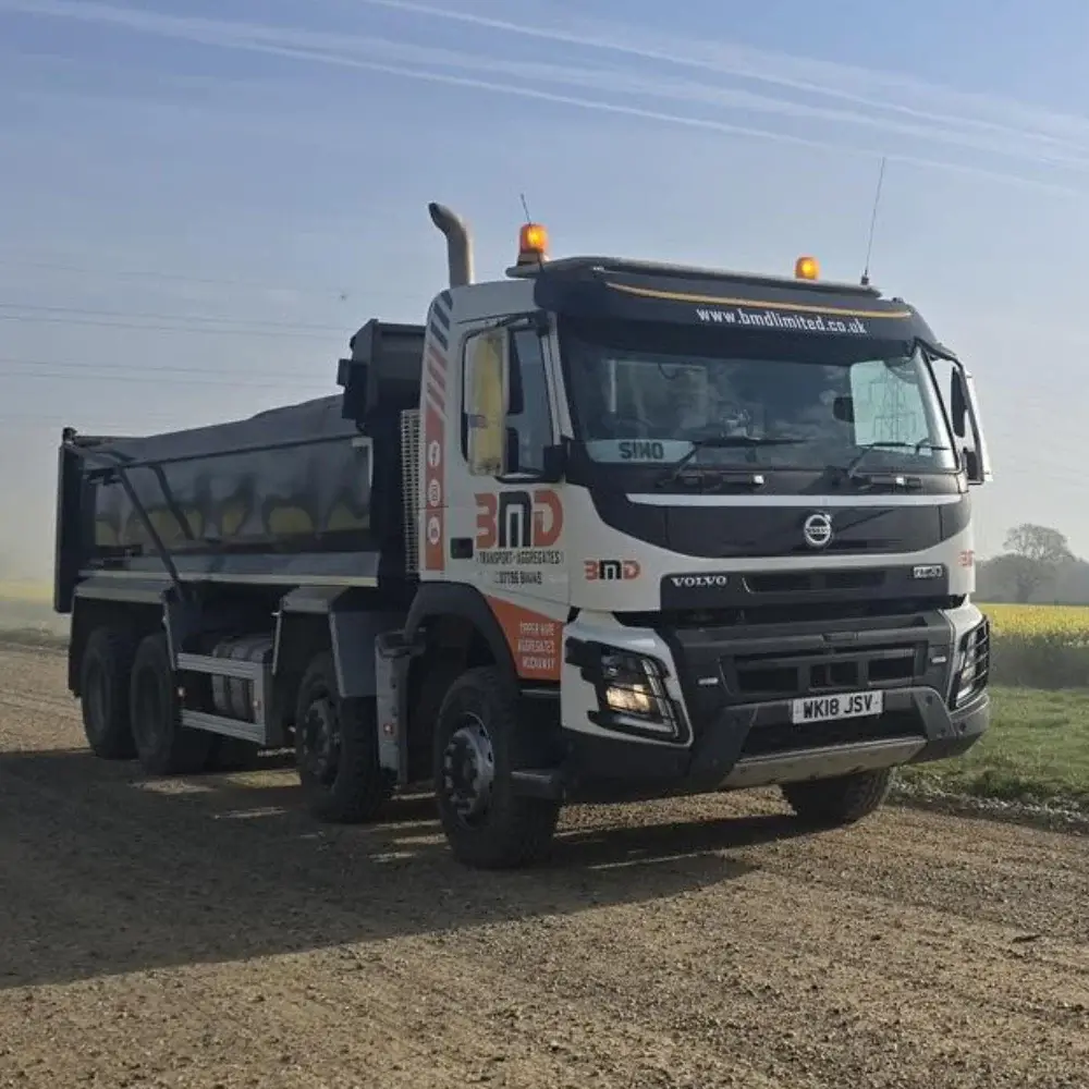 Bulk haulage tipper lorry transporting aggregates on rural construction route in Norfolk