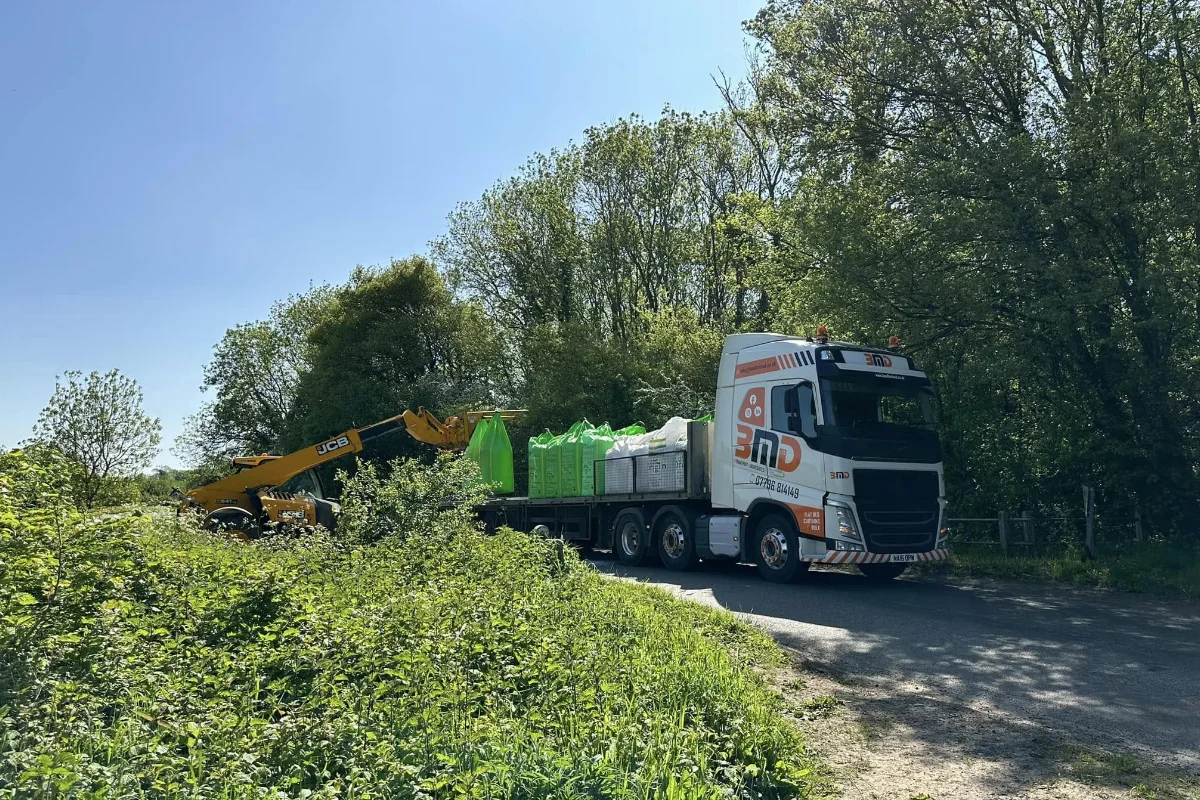 BMD lorry delivering bagged materials with a telehandler on a rural Norfolk road